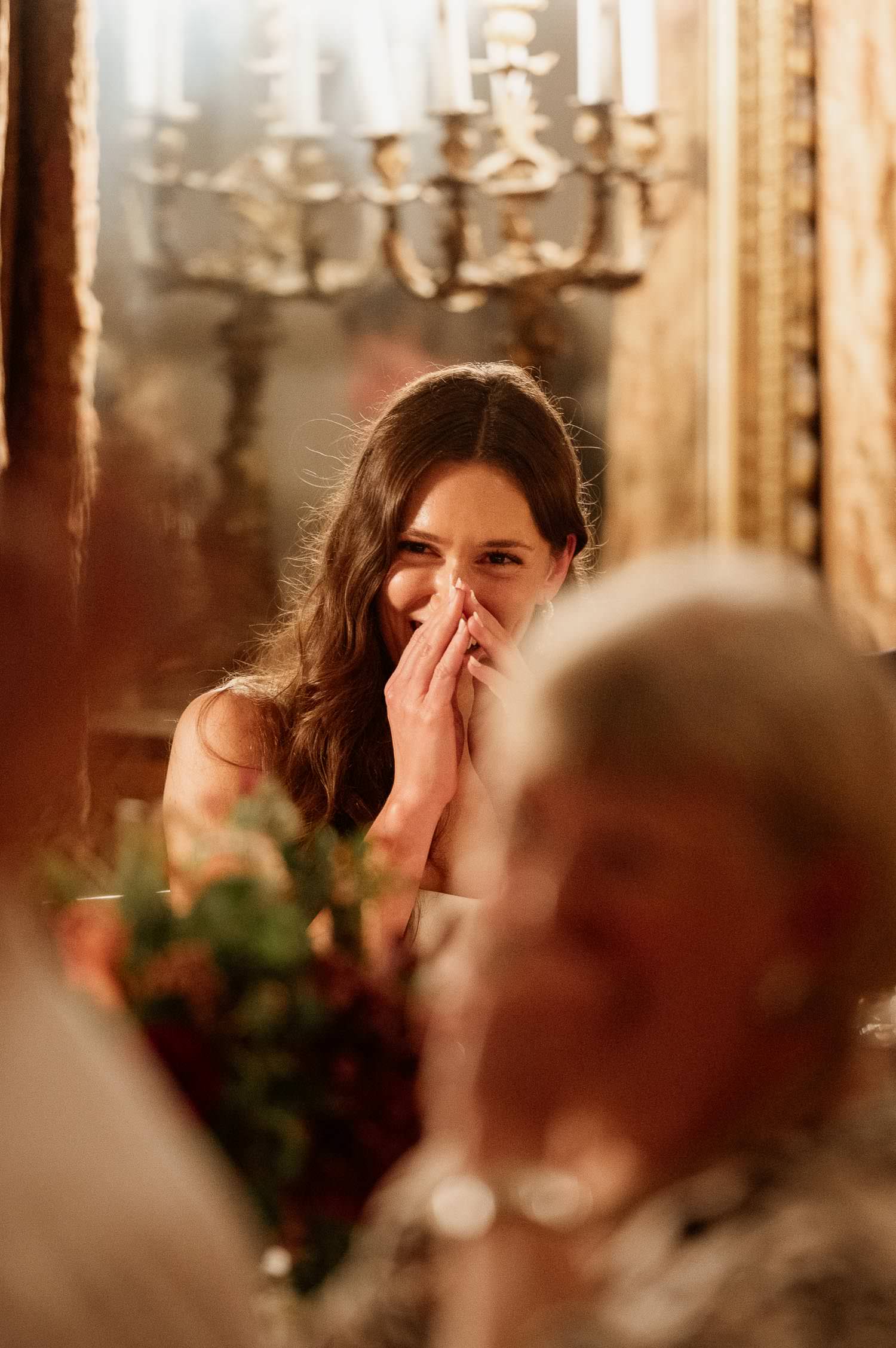 Bride blushing during the groom's speech.